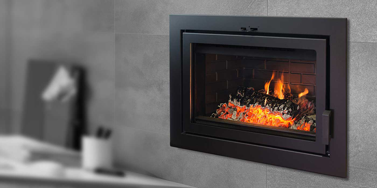 A close-up view of a traditional wood stove insert burning logs.