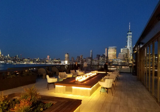 Linear fire pit on a river-front patio overlooking the city