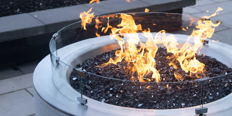 The FlameCraft ReForm Stack Gas Fire Pit with a tempered glass wind guard