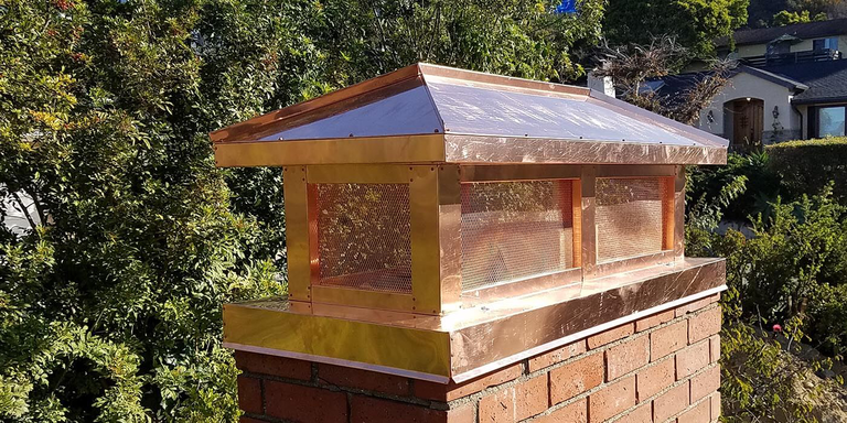 A custom decorative copper chimney shroud by the brand American Chimney Shroud