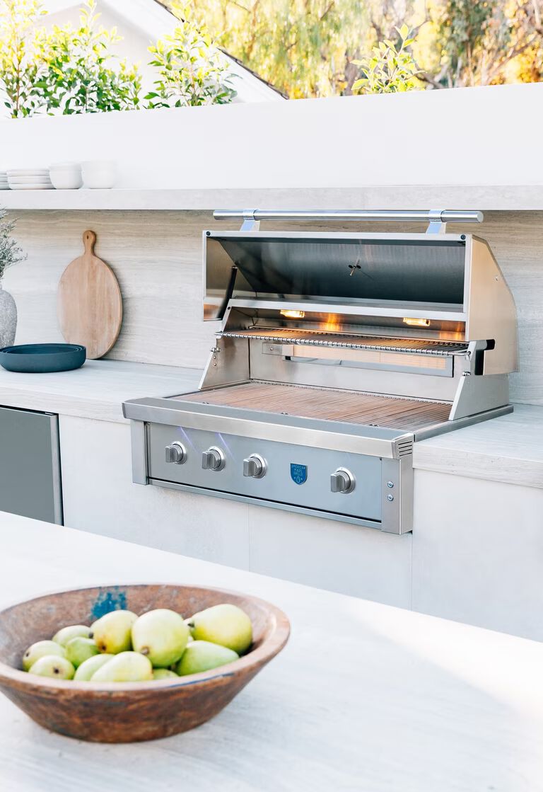 A built-in Summerset grill installed in a custom outdoor kitchen island