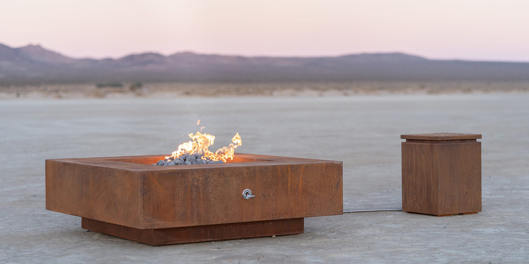 A Corten Steel gas fire pit and matching Propane tank enclosure made of Corten steel