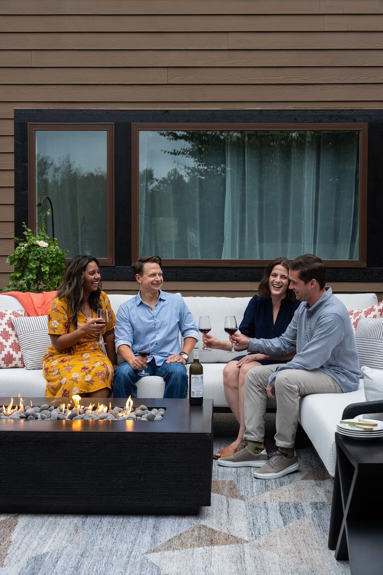 A group of four people sitting around a fire pit